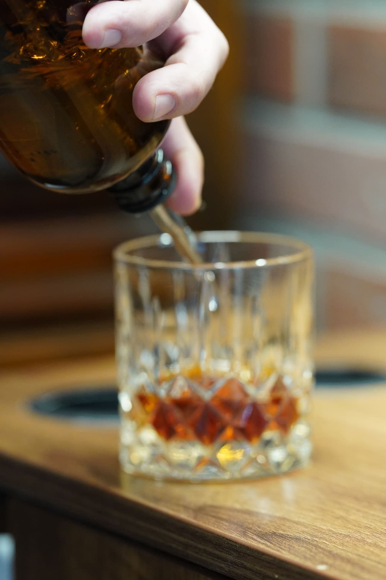 Bourbon being poured into crystal Old Fashioned glass