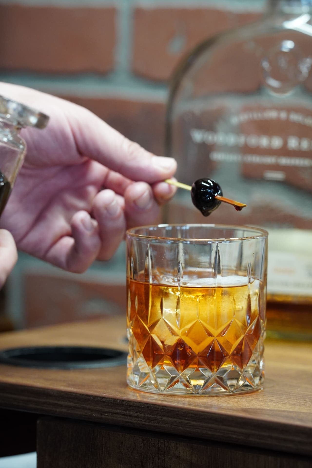 Old Fashioned garnished with cherry on gold pick