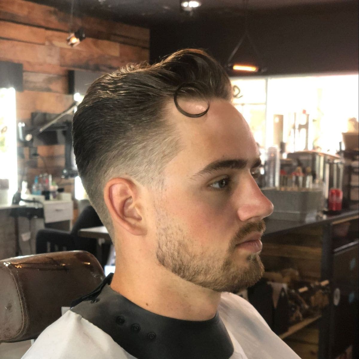 Pompadour fade with curled forelock detail