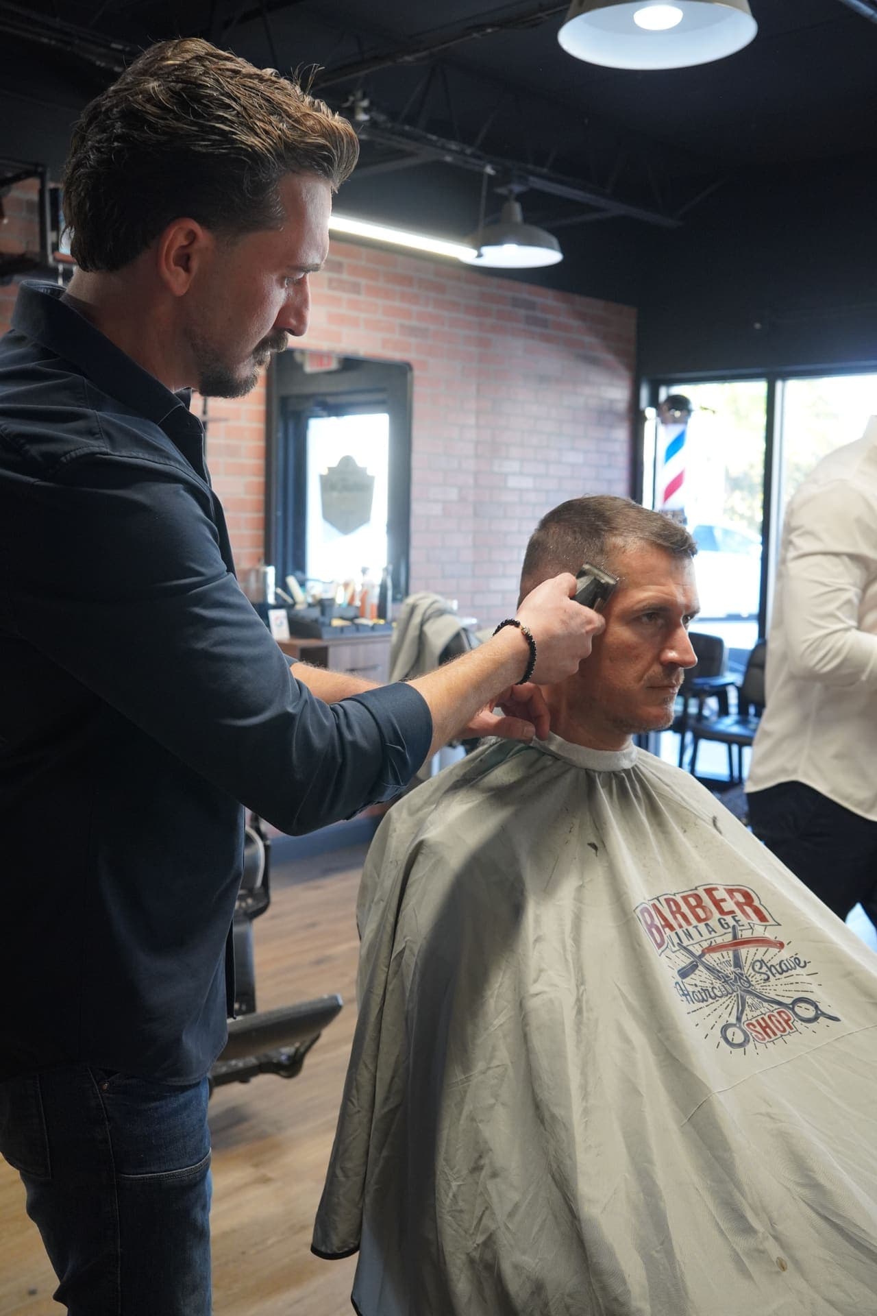 Barber and client at the chair with ring light