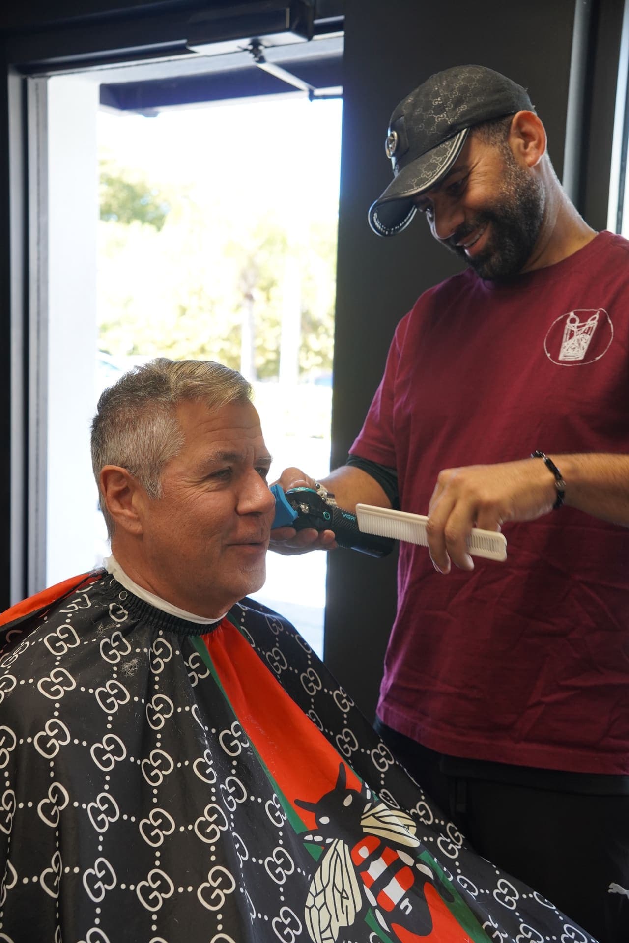 Barber trimming client's beard in the chair